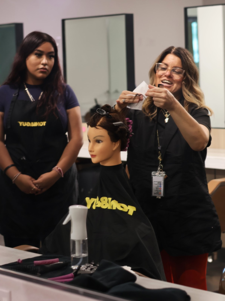 Cosmetology teacher, Brandie James, demonstrates to Majetzy Hernandez (12) how to do perms.
