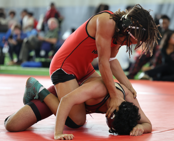 In the final period of his match, Daelyn Spencer (10) shoves his opponent down to secure the victory.